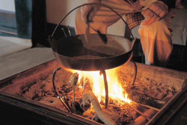 囲炉裏端で豆を炒る様子